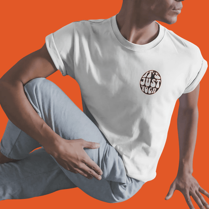 Model wearing "It's Just Yoga" unisex tee, radiating a carefree vibe in yoga pose on vibrant orange background.